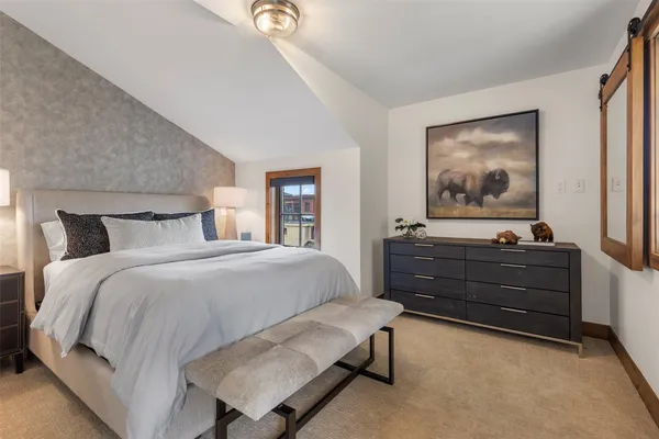 a bedroom with a large bed and a chandelier