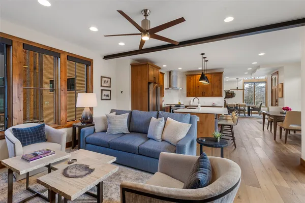 a living room with furniture kitchen view and a large window