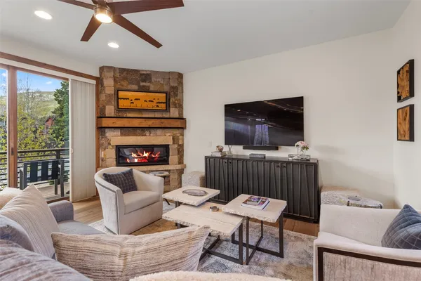 a living room with furniture a flat screen tv and a floor to ceiling window
