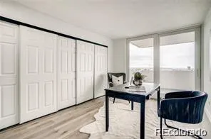 a view of a workspace with furniture and a window