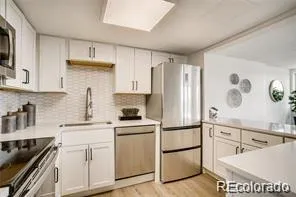 a kitchen with a sink a refrigerator and cabinets
