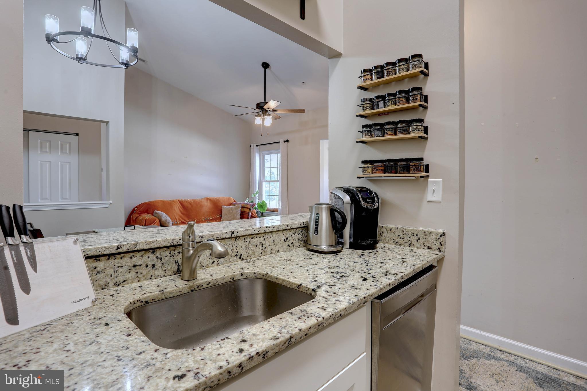 602 Moonglow Road, Unit 302 Odenton, MD 21113 - Photo 2 of 24 a kitchen with a sink dishwasher a dining table and chairs with wooden floor