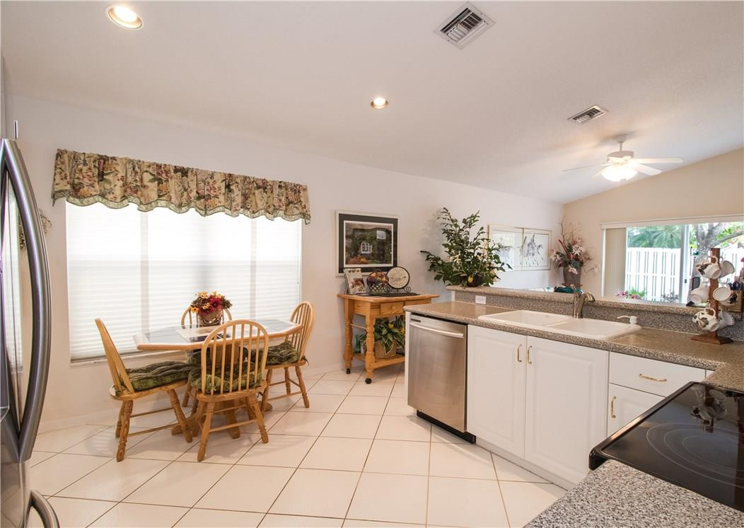 17445 Southwest 33rd Court Miramar, FL 33029 - Photo 9 of 23 a kitchen with a dining table chairs and white appliances