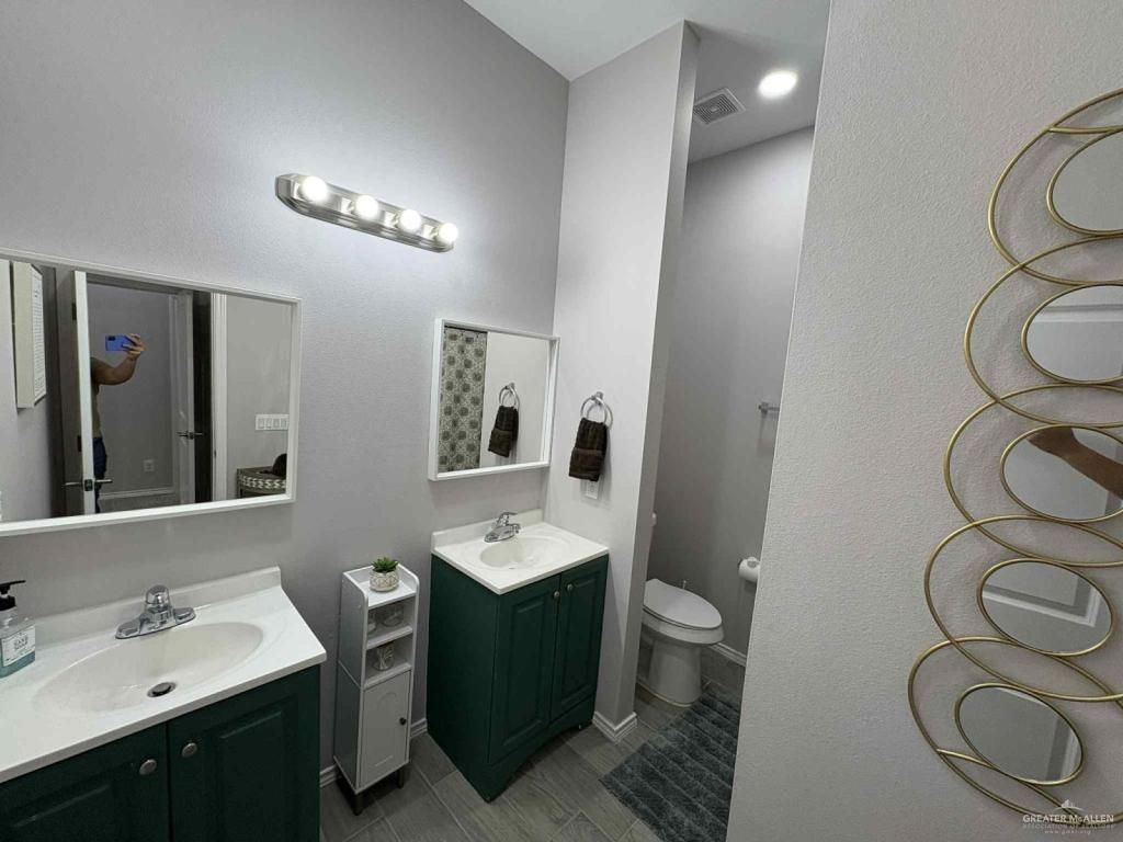 2007 Cassandra Street Mission, TX 78572 - Photo 5 of 10 a bathroom with a double vanity sink toilet and a mirror