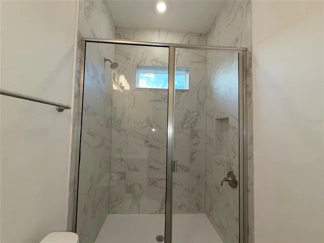 a bathroom with a glass shower door and mirror