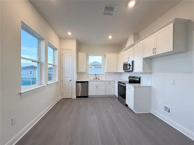 a kitchen with white cabinets and white appliances