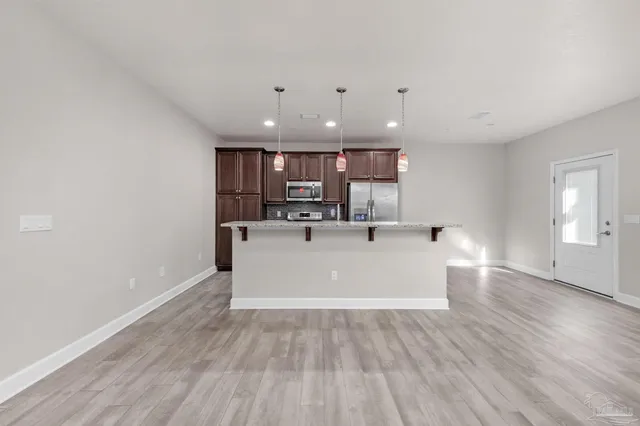 a view of kitchen with kitchen island microwave and wooden floor