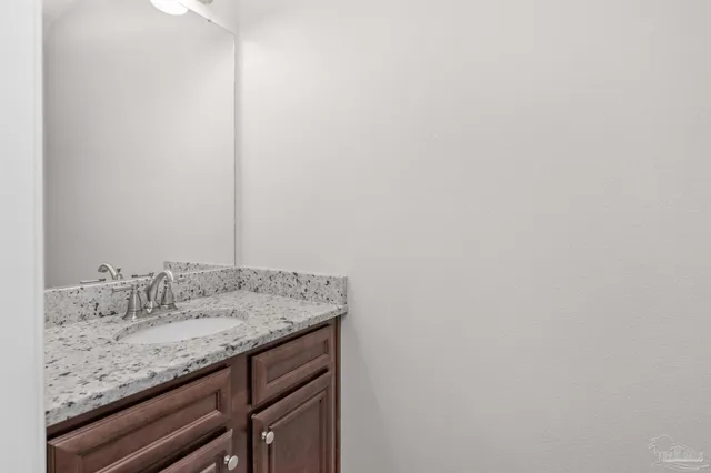 a bathroom with a granite countertop sink and vanity