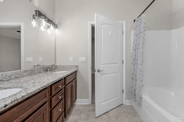 a bathroom with a granite countertop sink a mirror and a bathtub