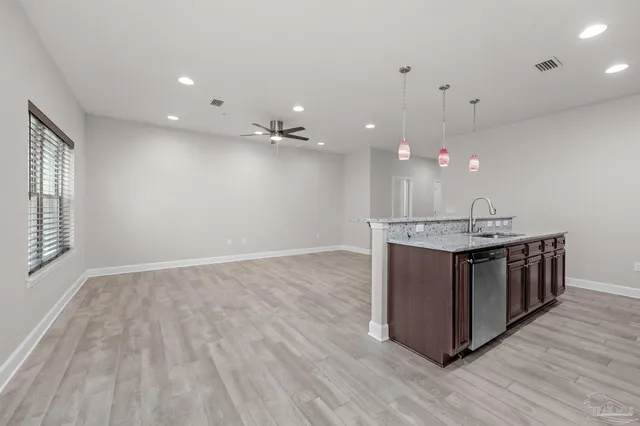 a kitchen with kitchen island sink and wooden floor