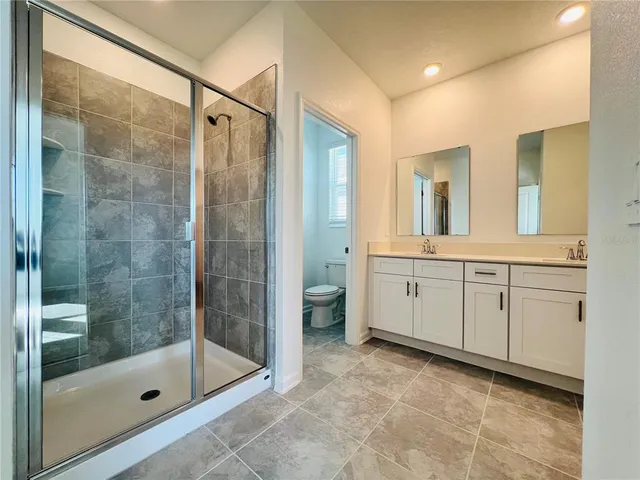 a bathroom with a double vanity sink toilet and shower