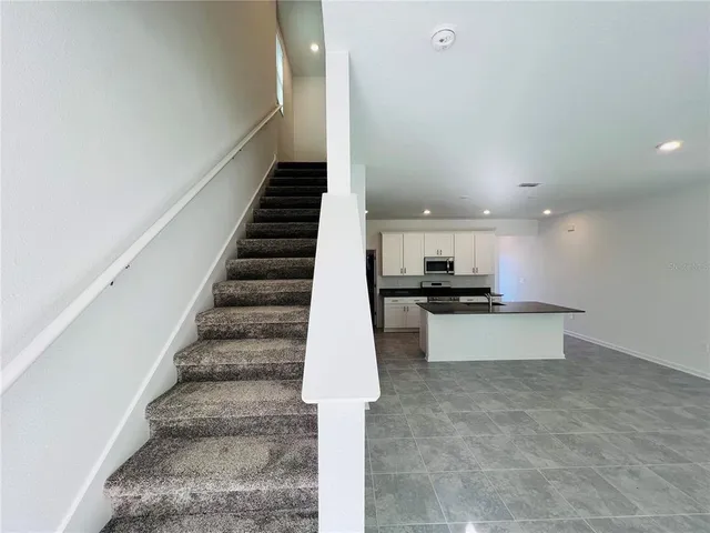 a view of kitchen with sink and refrigerator