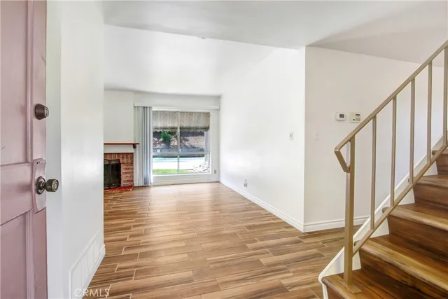 a view of empty room with wooden floor and fireplace