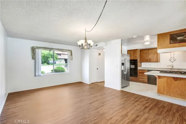 a view of a kitchen with wooden floor and stainless steel appliances