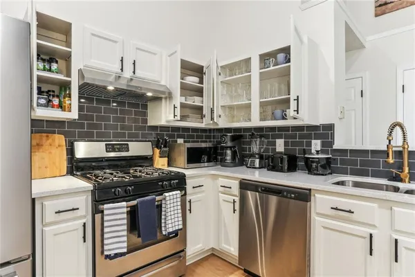 a kitchen with stainless steel appliances granite countertop a stove and cabinets