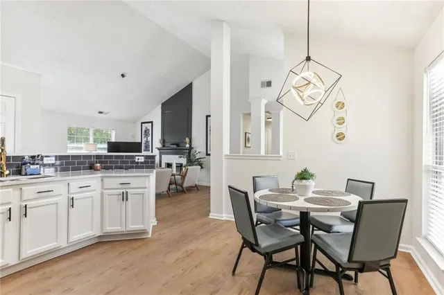 a view of a dining room with furniture a chandelier and wooden floor