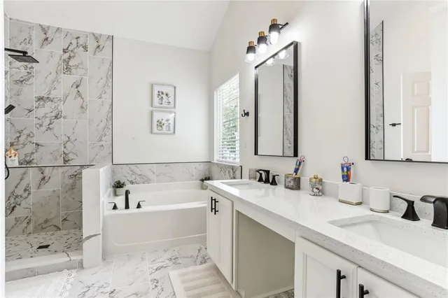 a bathroom with a tub sink and mirror