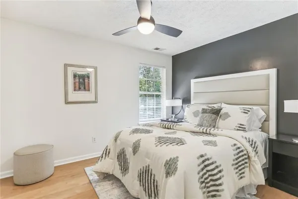 a bedroom with a bed and a painting on the wall