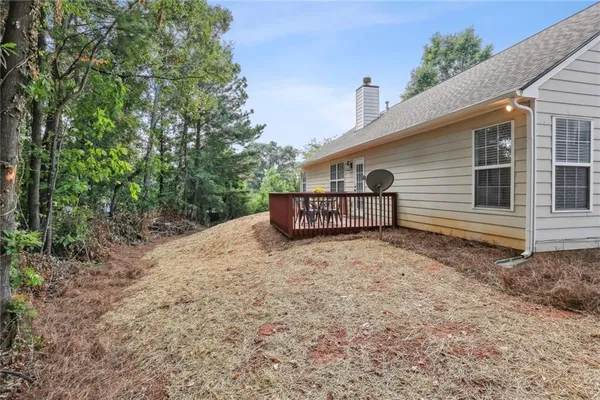 a backyard of a house with barbeque oven and trees