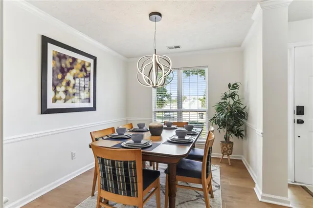 a dining room with furniture a chandelier and wooden floor