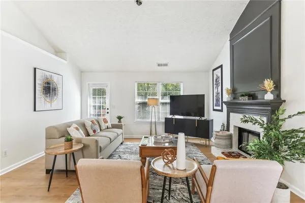 a living room with furniture a fireplace and a flat screen tv