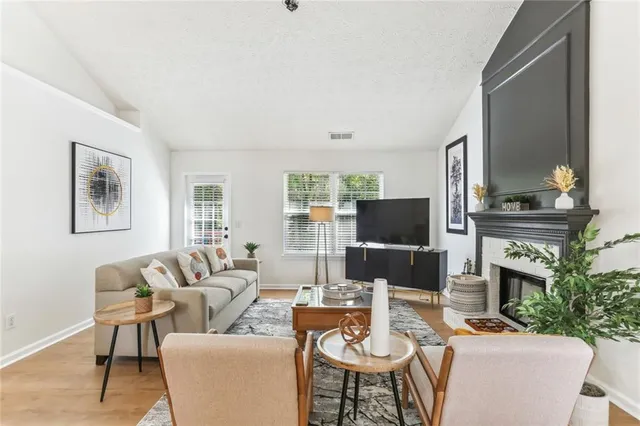 a living room with furniture a fireplace and a flat screen tv