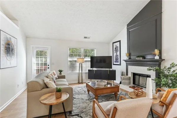 a living room with furniture a fireplace and a flat screen tv