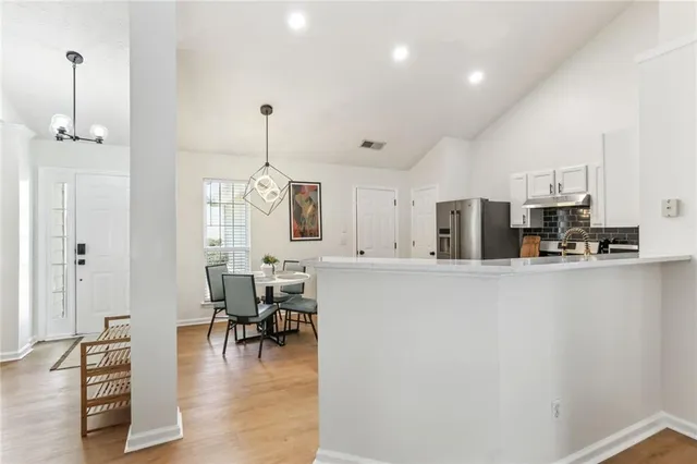 a kitchen with stainless steel appliances a refrigerator and a stove top oven