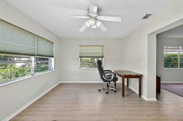 a view of a workspace with furniture and a window