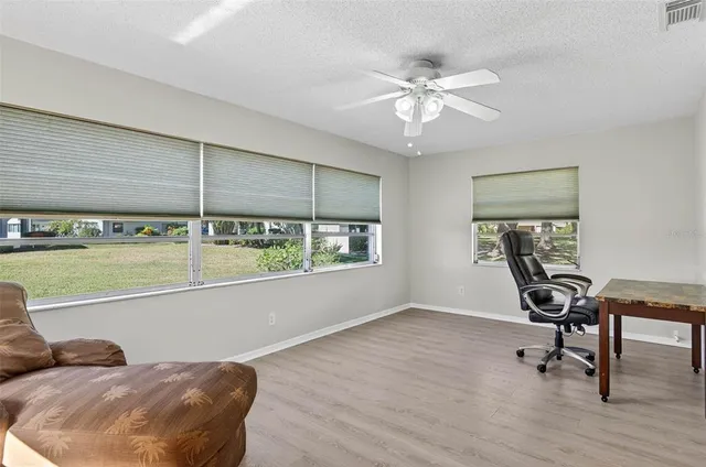 a view of a workspace with furniture and a window