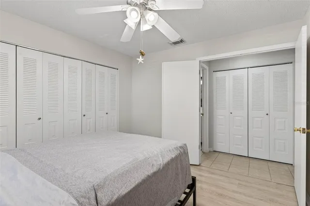 wooden floor in an empty room with a chandelier fan