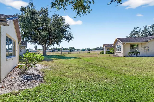 an aerial view of a house with a yard and tennis court