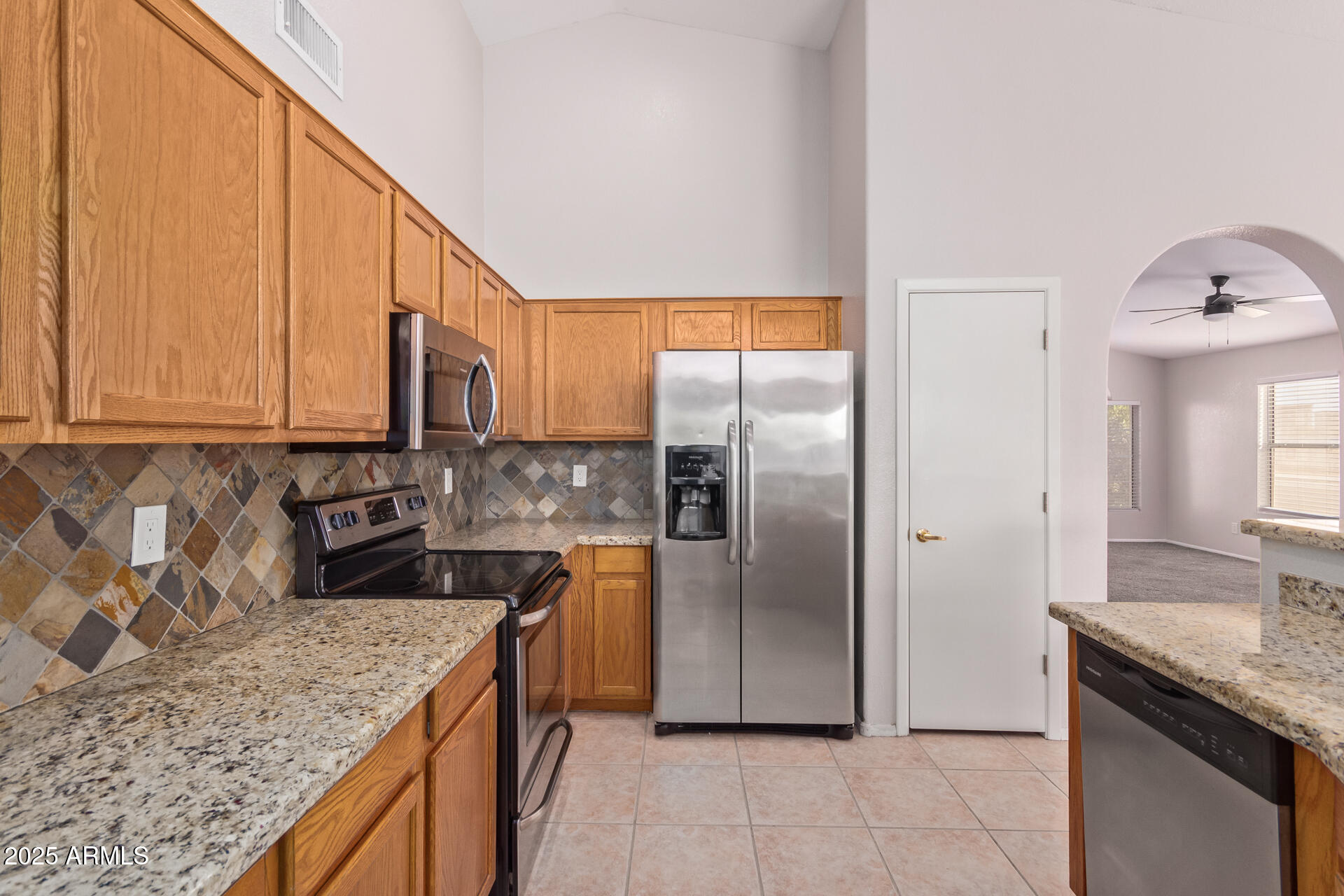 208 East Devon Drive Gilbert, AZ 85296 - Photo 13 of 37 a kitchen with stainless steel appliances granite countertop a sink a stove and a refrigerator