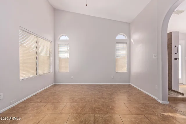 an empty room with windows and mirror