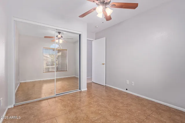 a view of an empty room with a window and a ceiling fan