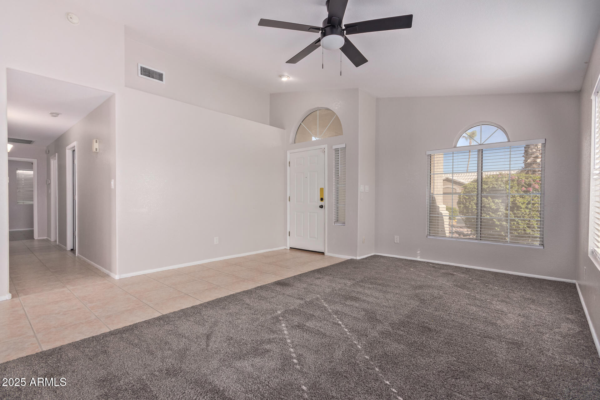 208 East Devon Drive Gilbert, AZ 85296 - Photo 4 of 37 an empty room with chandelier fan and windows