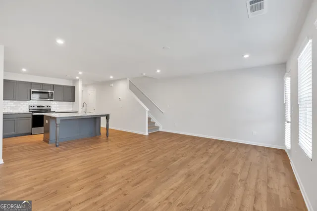 a view of kitchen with kitchen island granite countertop a stove top oven and a sink with granite countertops