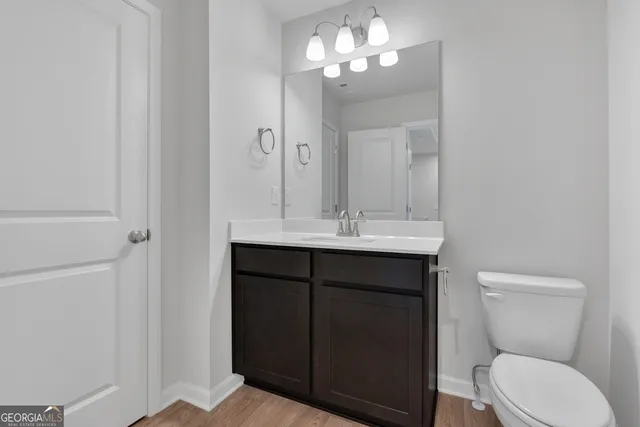 a bathroom with a toilet a sink and mirror