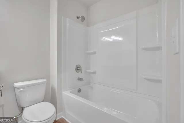 a white toilet sitting next to a bath tub