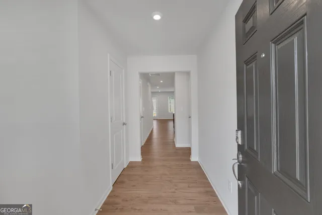 a view of a hallway with wooden floor