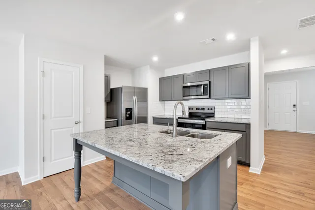 a kitchen with granite countertop kitchen island sink refrigerator and stove
