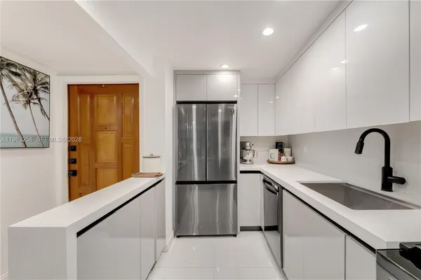 a kitchen with stainless steel appliances a refrigerator sink and cabinets