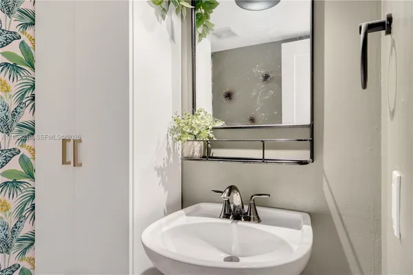 a bathroom with a sink a toilet and a mirror