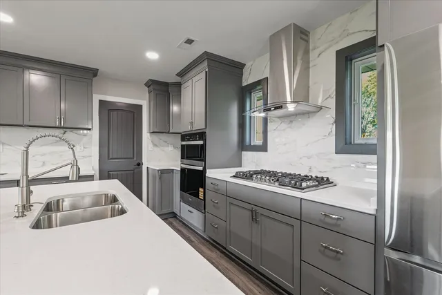 a kitchen with stainless steel appliances granite countertop a sink stove and refrigerator