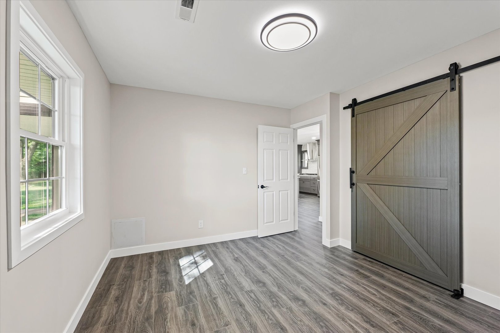 402 Beeson Road Urbana, IL 61802 - Photo 17 of 33 a view of an empty room with wooden floor and a window