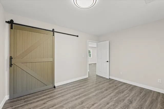 an empty room with wooden floor and white walls