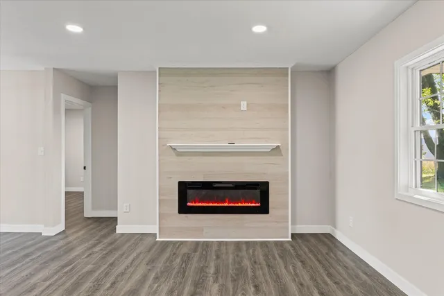 an empty room with wooden floor and fireplace