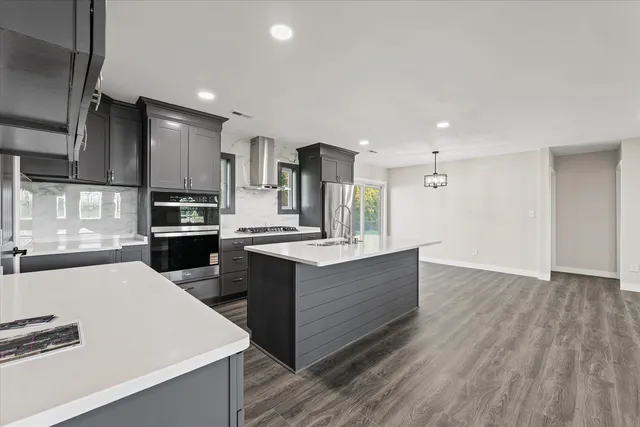 a kitchen with kitchen island sink stove and cabinets