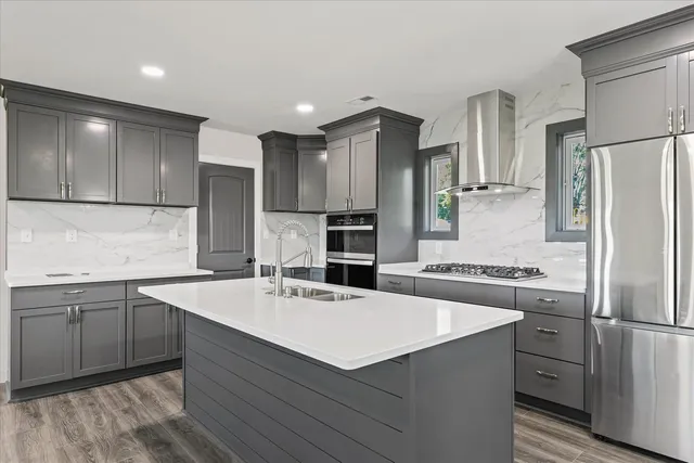 a kitchen with a sink refrigerator and cabinets