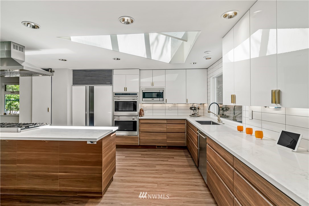 12833 Southeast 45th Place Bellevue, WA 98006 - Photo 12 of 40 a large kitchen with stainless steel appliances kitchen island a large counter and a view of living room